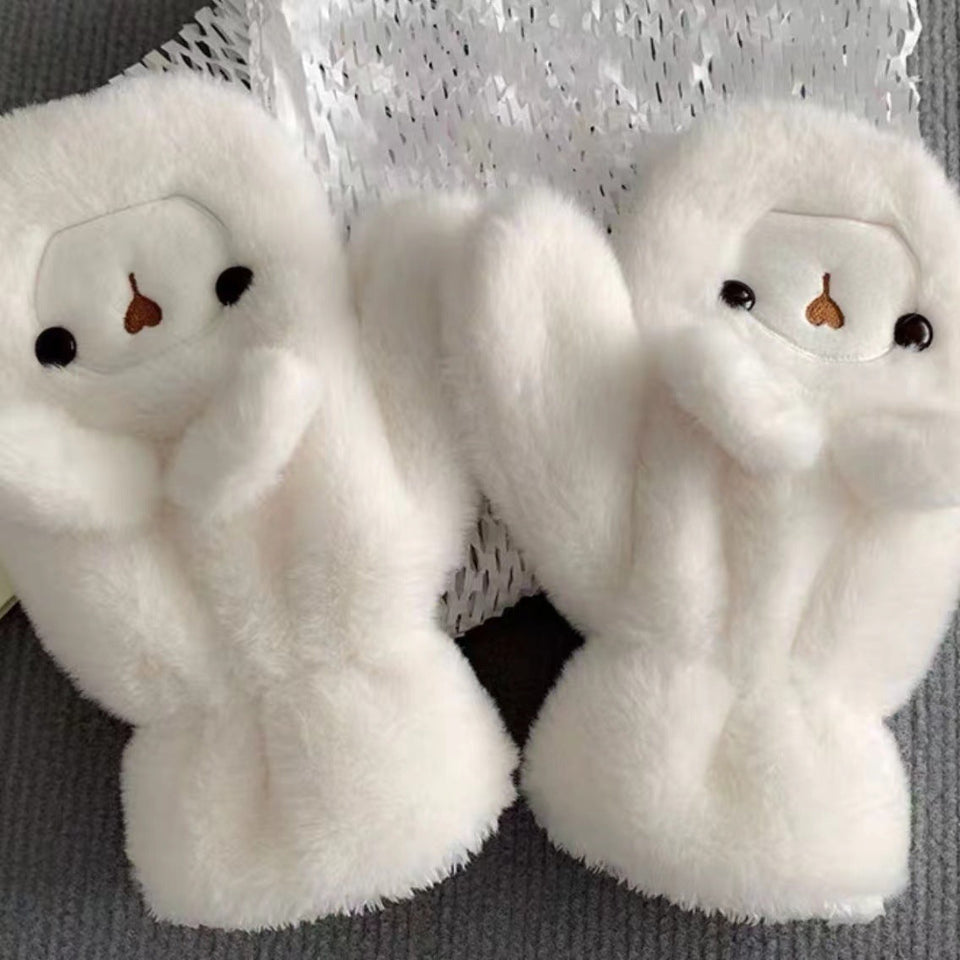 Woman wearing a cute plush bear winter hat with matching warm gloves in cream color.