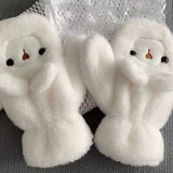 Woman wearing a cute plush bear winter hat with matching warm gloves in cream color.