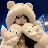 Woman wearing a cute plush bear winter hat with matching warm gloves in cream color.