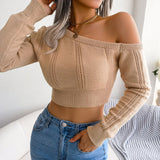 Woman wearing a cream off-shoulder long sleeve knit sweater with jeans.
