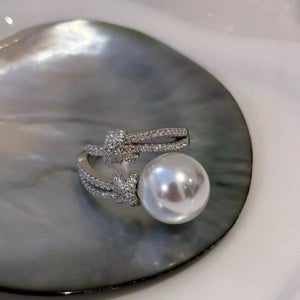 Elegant pearl zircon bypass ring with a synthetic pearl and sparkling zircon accents in a modern open design.