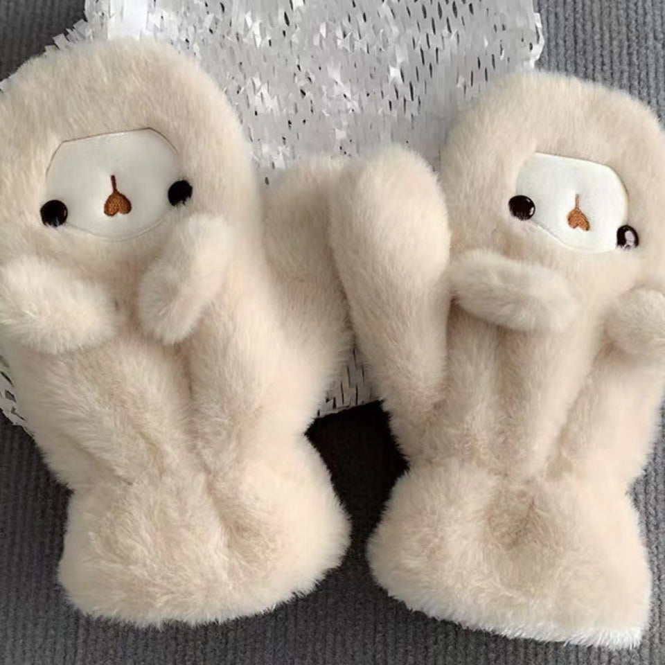 Woman wearing a cute plush bear winter hat with matching warm gloves in cream color.