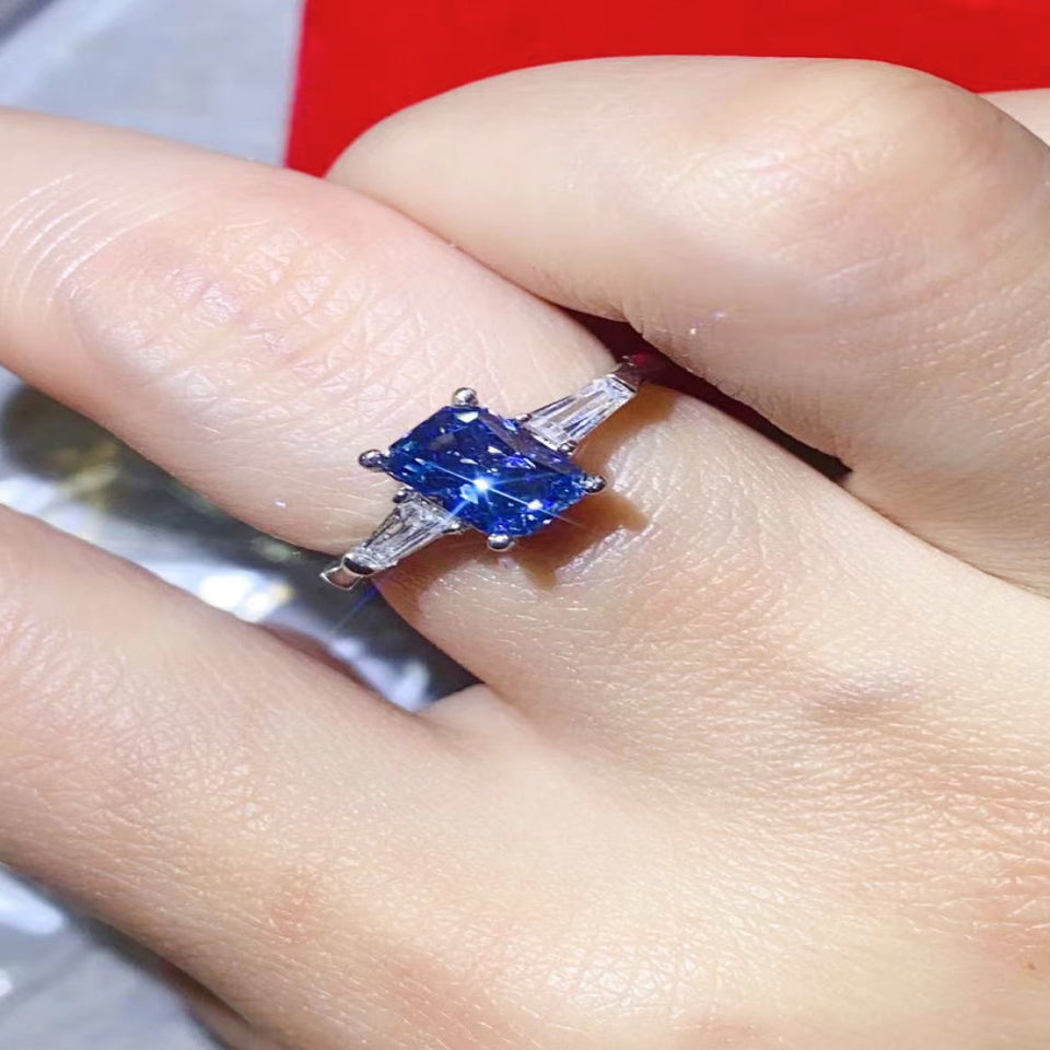1 carat blue rectangle moissanite ring with a platinum-plated finish and brilliant sparkling gemstone.